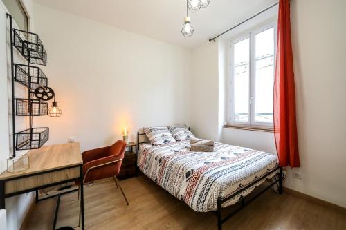 1 dormitorio con cama, escritorio y ventana en Le lavandin, spacieux et moderne P4, centre ville, wifi, en Nimes