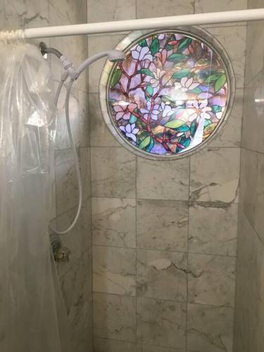 a bathroom with a shower with a stained glass window at Hawaii Tropical Volcano mansion + Sauna in Hilo