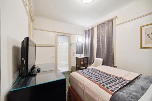 a hotel room with a bed and a flat screen tv at Union Square Plaza Hotel in San Francisco