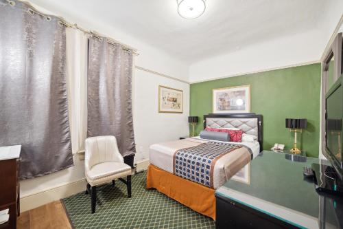 a small bedroom with a bed and a chair at Union Square Plaza Hotel in San Francisco