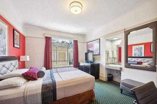 a hotel room with a bed and a mirror at Union Square Plaza Hotel in San Francisco