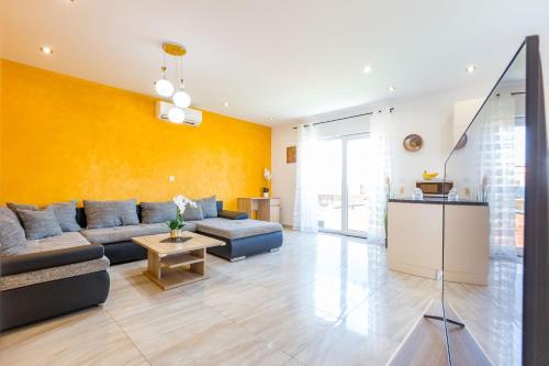 ein Wohnzimmer mit einem Sofa und einer gelben Wand in der Unterkunft KM Exclusive Apartments in Zadar