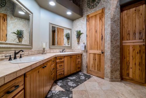 a bathroom with a sink and a wooden door at Quail Mountain Desert Resort: Heated Pool, Mt Vews, all BR's King & TV's, Hiking in Mesa