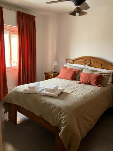Un dormitorio con una cama grande con dos toallas encima. en Departamento General Acha, en San Juan