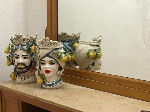 deux masques assis sur un comptoir devant un miroir dans l'établissement Agrolea, à Terme Vigliatore