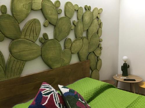 a bedroom with a cactus mural on the wall at Agrolea in Terme Vigliatore