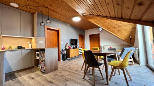 - une cuisine et une salle à manger avec une table et des chaises dans l'établissement SnežienkaD, à Vysoké Tatry