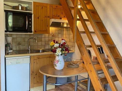 une cuisine avec un vase de fleurs sur une table dans l'établissement Appartement spacieux à Châtel proche centre, 7 couchages, balcon sud, parking, Multi Pass inclus! - FR-1-693-58, à Châtel