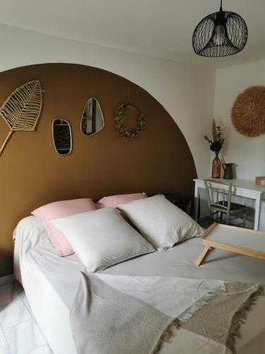 um quarto com uma cama grande com almofadas cor-de-rosa e brancas em Les petites chambres de Lacoste em Lacoste