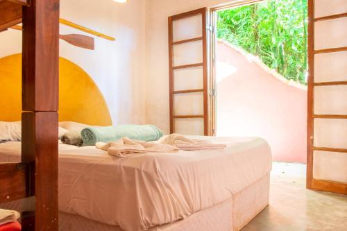 a bedroom with two bunk beds and a ladder at Sambaqui Hostel in Ilhabela