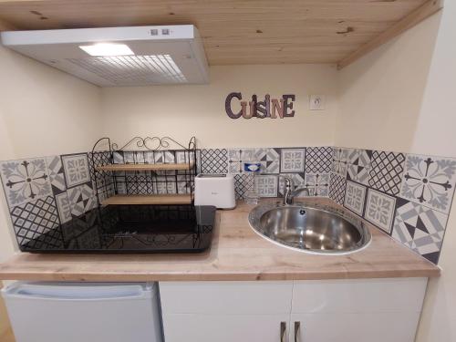 La salle de bains est pourvue d'un lavabo et d'un panneau indiquant la cuisine. dans l'établissement Epernay Capital de Champagne, à Épernay