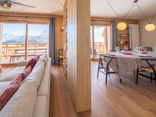 un salon avec une table et une salle à manger dans l'établissement Ski-in/Ski-out à l'Alpe d'Huez: Appartement 130m² avec Piscine, Sauna et Hammam - FR-1-645-21, à Huez