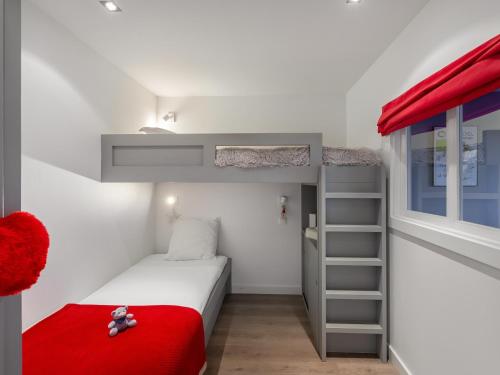 une petite chambre avec un lit superposé et une couverture rouge dans l'établissement Appartement central à Courchevel 1650 avec accès direct aux pistes et WiFi - FR-1-563-117, à Courchevel