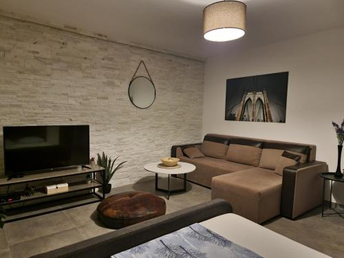 a living room with a couch and a tv at Apartments Vraneš Tivat in Tivat