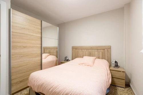 um quarto com 2 camas e lençóis cor-de-rosa em Apartamento en Santoña em Santoña