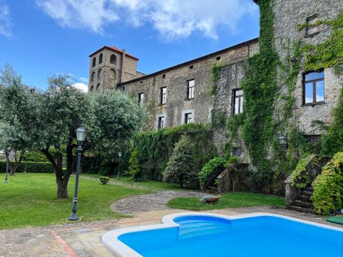 un edificio antiguo con una piscina frente a él en Relais Castello Vassallo, en Stella Cilento