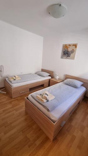 two beds in a room with wooden floors at Kuća za odmor Nadia Brseč in Brseč