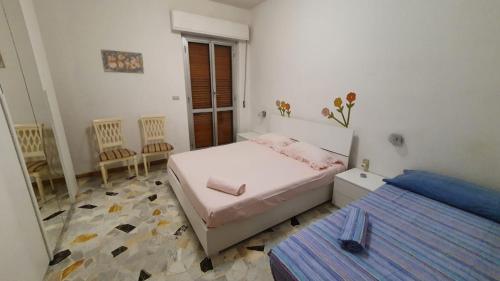 1 dormitorio con 1 cama, 2 sillas y ventana en Buona vacanza en Arenzano