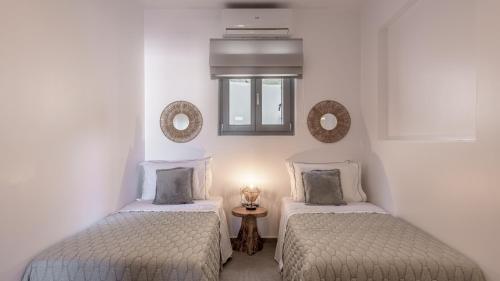 two twin beds in a room with white walls at Esperanza Apartments in Adamantas
