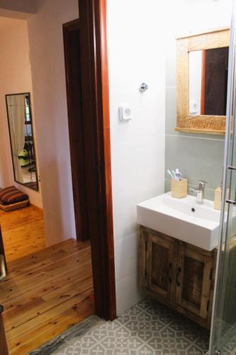 a bathroom with a sink and a mirror at The Sisters Beach House in Vathírrevma