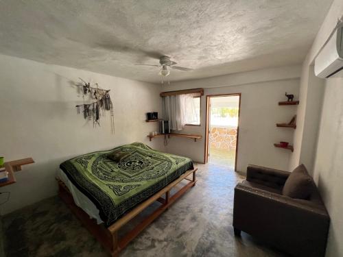 1 dormitorio con cama y sofá en Casa Gajah Hotel Cuyo, en El Cuyo