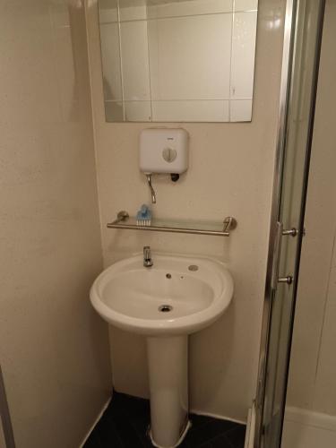 y baño con lavabo blanco y espejo. en Guest House Private Room near Glasgow City Centre St George's Rd, en Glasgow