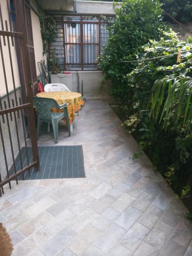 un patio con mesa y sillas en un porche en Buona vacanza en Arenzano