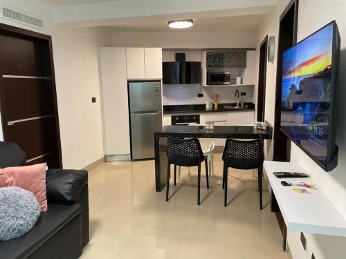 uma cozinha e sala de estar com uma mesa preta e cadeiras em Elegante apartamento en Playa el Angel em Porlamar