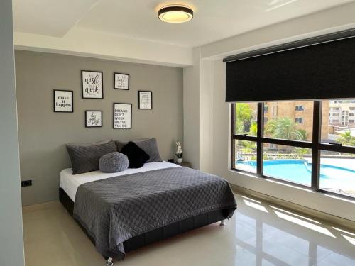 a bedroom with a bed and a large window at Elegante apartamento en Playa el Angel in Porlamar