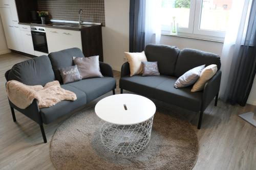 a living room with two couches and a table at Domo Dolce Wohnapartment in Appel