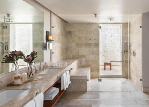 a bathroom with a large sink and a shower at Fairmont Heritage Place Mayakoba in Playa del Carmen
