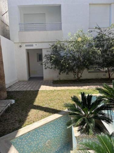 a house with a swimming pool in front of a building at Duplex à Hammamet centre in Hammamet Sud