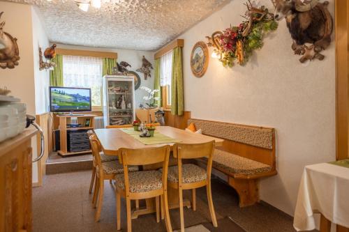 a dining room with a table and chairs and a television at Haus Waldrast in Kappl