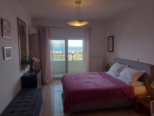 a bedroom with a bed and a window and a couch at Adromeda Aegean Sea View villa in Koskinou