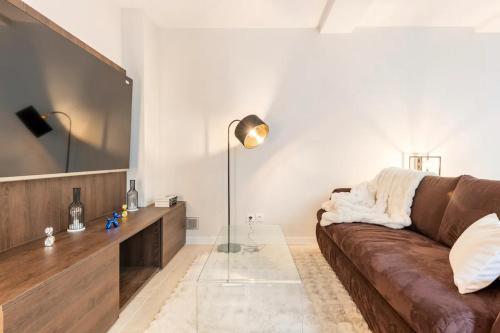 a living room with a brown couch and a mirror at Cocoon du vieux Lyon - Luxury apartment - Balneo in Lyon