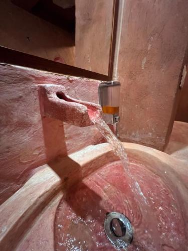 a sink with water coming out of a faucet at Casa Gajah Hotel Cuyo in El Cuyo