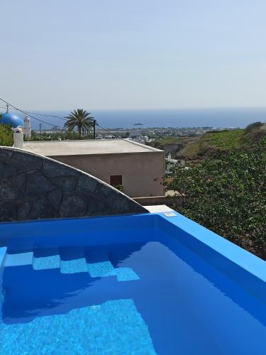 a blue swimming pool on top of a house at Amphitrite Suites Santorini in Vóthon