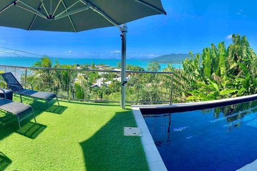a view of the ocean from a house with a swimming pool at Whitsunday Dreams in Airlie Beach