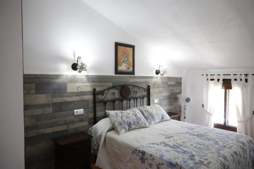 グラサレマにあるPlaza de los asomaderos 54 Grazalemaのレンガの壁、ベッド付きのベッドルーム1室