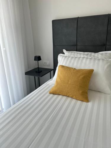 a white bed with a yellow pillow on it at AURUS in Korčula