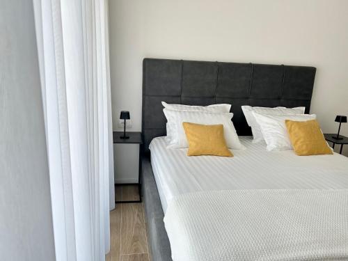a bedroom with a large bed with two yellow pillows at AURUS in Korčula
