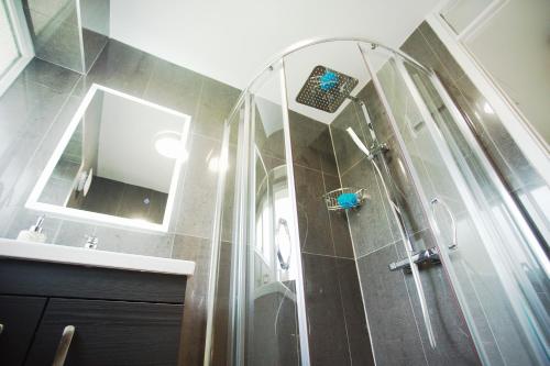 een badkamer met een douche, een spiegel en een wastafel bij Tree View Apartment in Chesterton