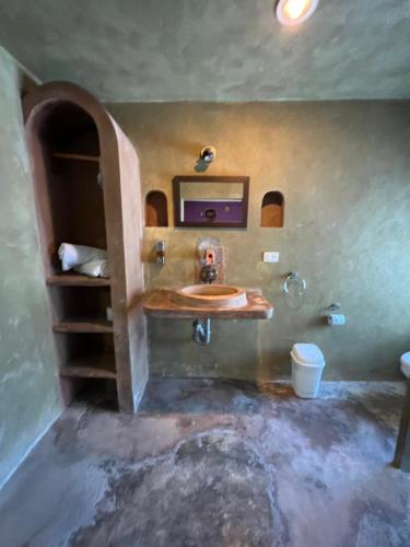 y baño con lavabo y espejo. en Casa Gajah Hotel Cuyo, en El Cuyo