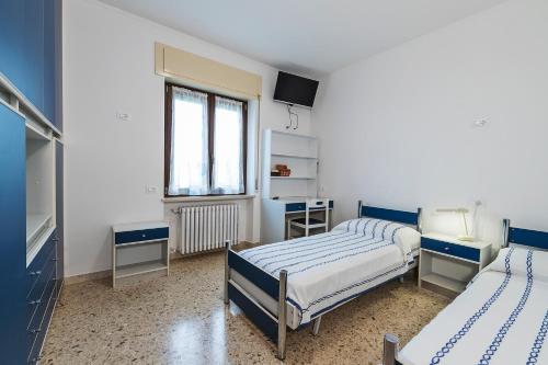 sypialnia z 2 łóżkami i oknem w obiekcie Casa MONTE CROCE w mieście Corbiolo