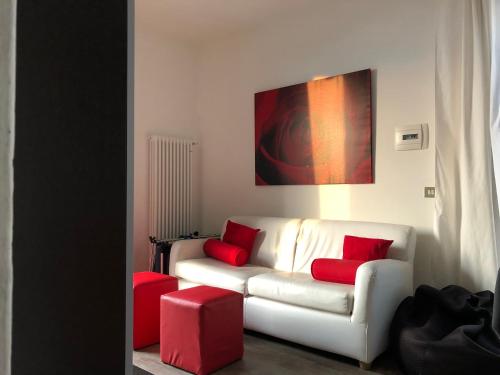 een woonkamer met een witte bank en rode kussens bij Apartment Claudia Malcesine in Malcesine