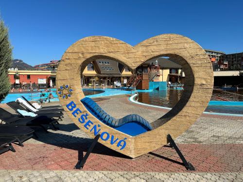 a sign in the shape of a heart next to a swimming pool at Apartmán Bešeňová 289 in Bešeňová