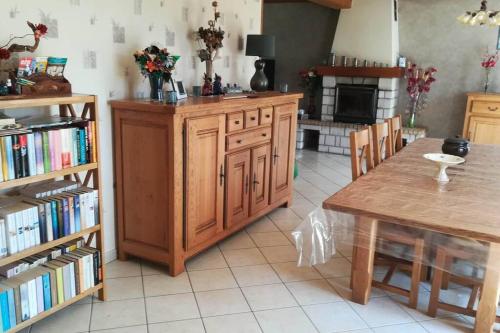 une cuisine avec une table et une étagère avec des livres dans l'établissement La Vallée en Cotentin, à Le Theil