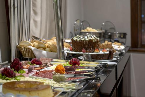 una línea de buffet con muchos tipos diferentes de comida en Hotel Laghetto Moinhos en Porto Alegre