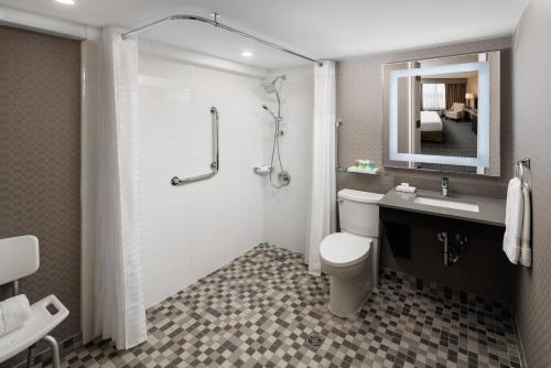 y baño con aseo, lavabo y ducha. en Pomeroy Hotel & Conference Centre, en Grande Prairie