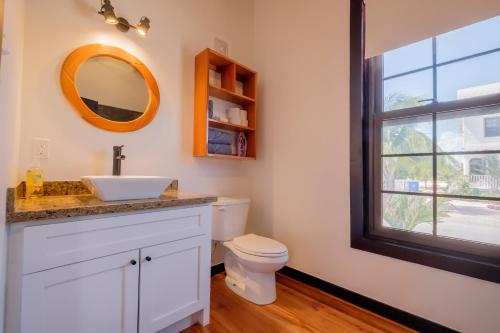 a bathroom with a sink and a toilet at Caribbean Vacation Rentals and The PoolClub at Mahogany! in San Pedro